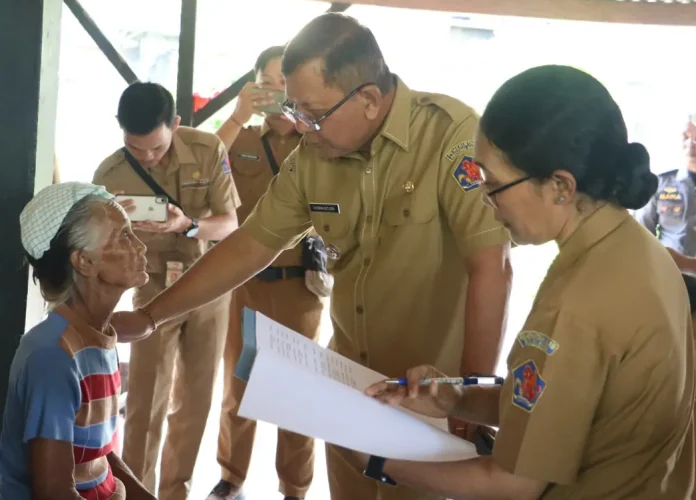 Bupati Buleleng I Nyoman Sutjidra menyerahkan bantuan sosial kepada warga Kelurahan Penarukan, Kecamatan Buleleng, Senin (8/9/2025).