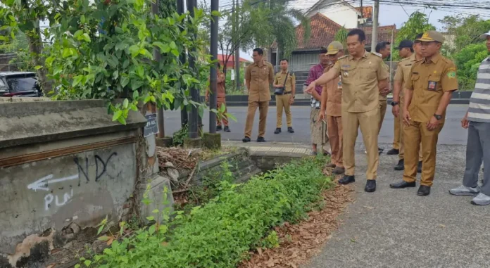 Bupati Jembrana I Made Kembang Hartawan meninjau rencana perbaikan jalan di Baler Bale Agung sambil mendorong warga mengelola sampah dari sumbernya.