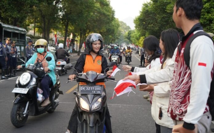 Warga yang melintas di kawasan Jalan Ngurah Rai, Singaraja, Jumat (7/8/2026), mendapat bendera Merah Putih secara cuma-cuma. Sebanyak 1.600 bendera dibagikan dalam aksi yang digelar menjelang peringatan HUT ke-81 Kemerdekaan Republik Indonesia.